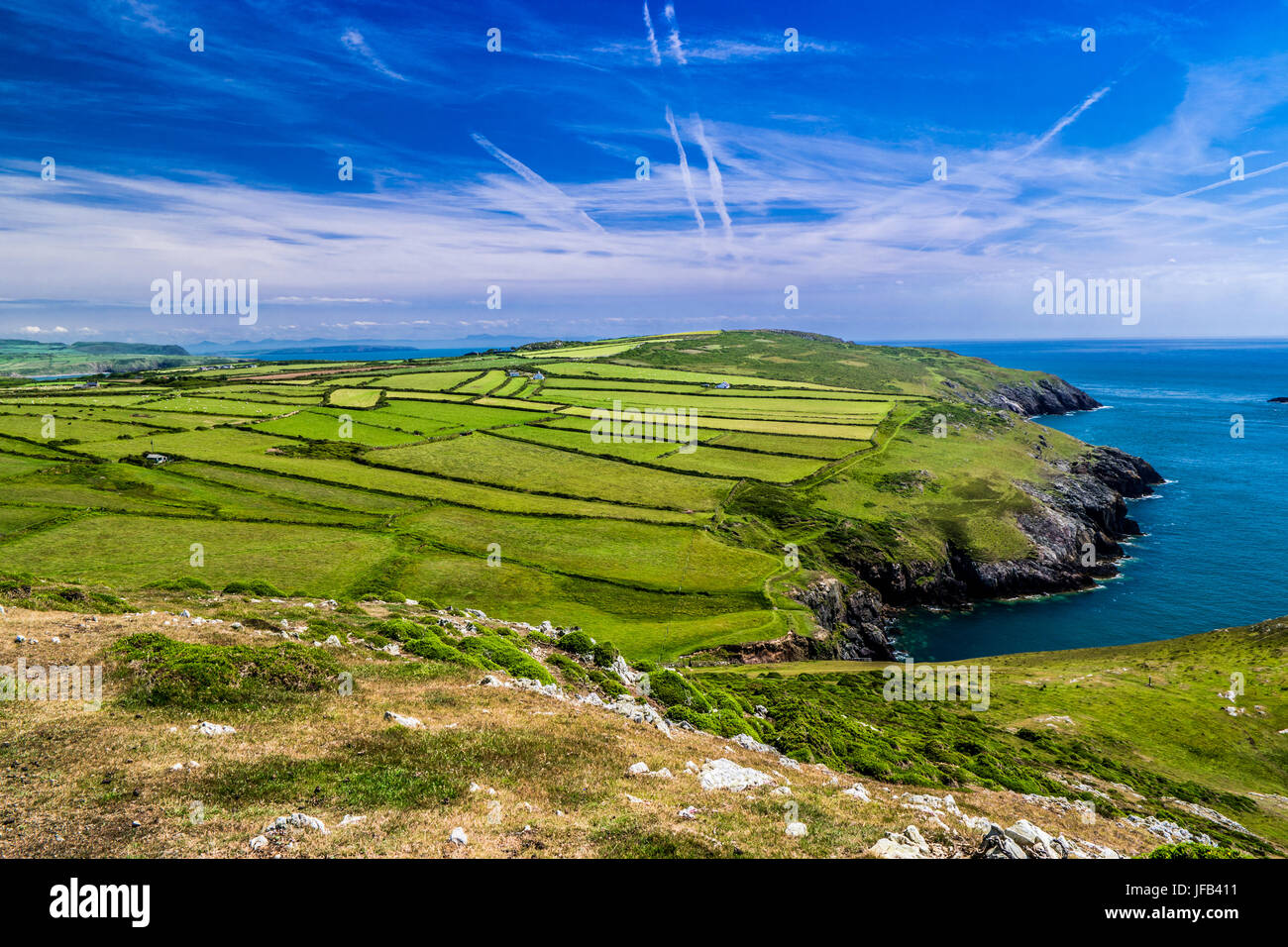 Lleyn peninsula coast with green fields and blue sea with cliffs near Aberdaron Stock Photo