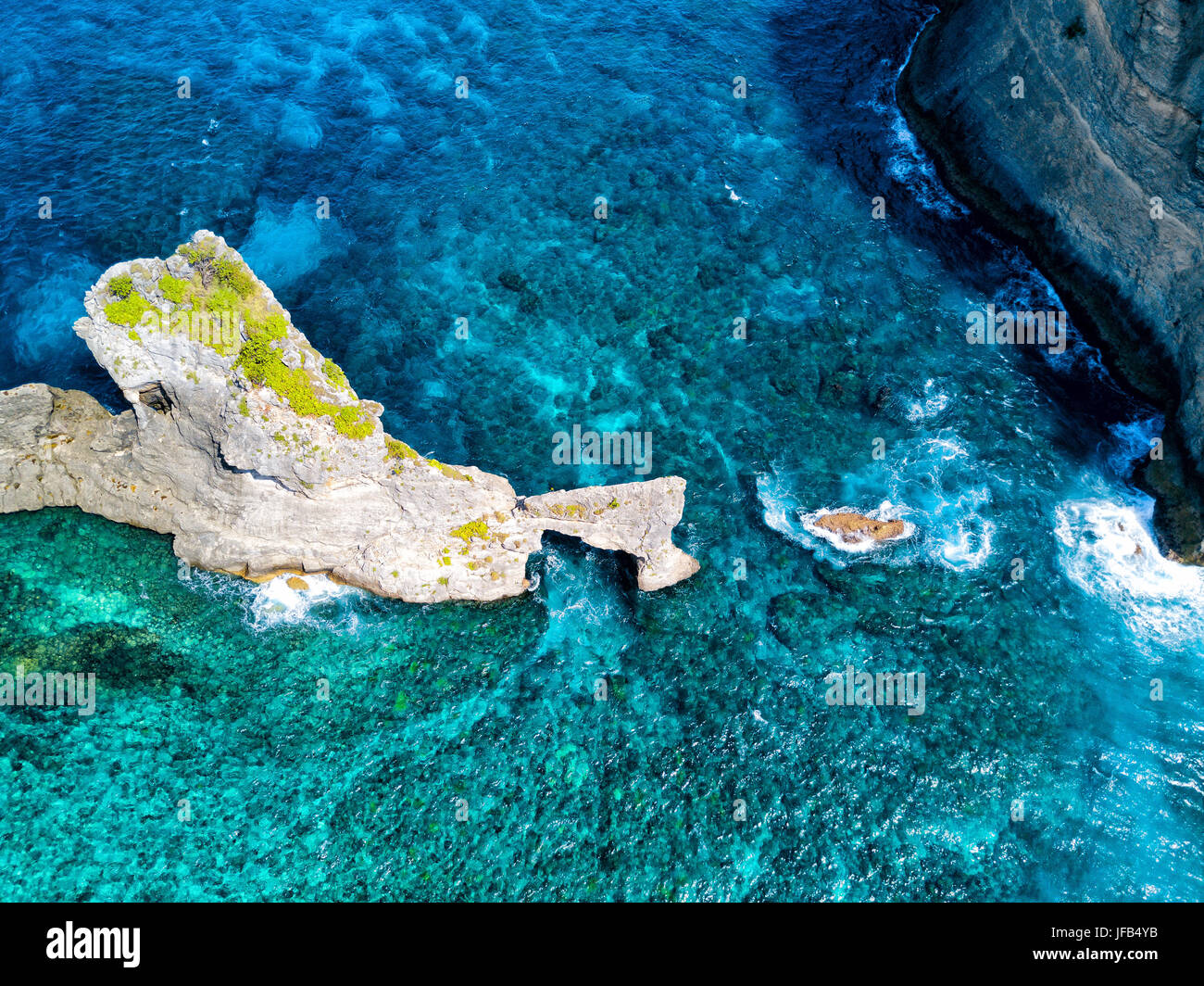 Aerial view of the coral reef surrounding the natural arch near Atuh Beach on Nusa Penida, Bali, Indonesia. Stock Photo