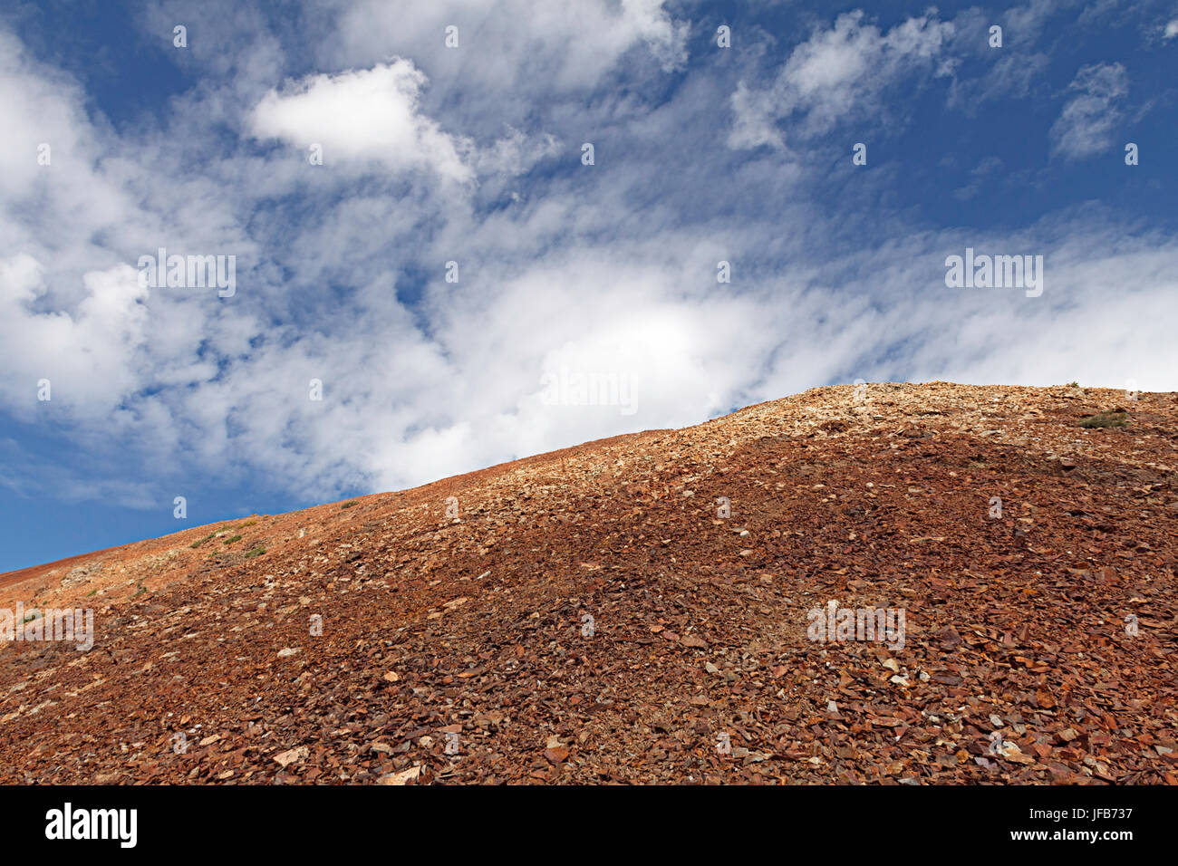A scree-laden Cross Mountain with clouds overhead. Stock Photo