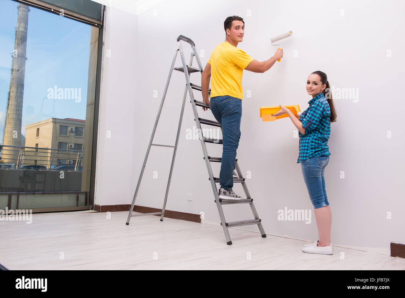 Young couple painting wall at home Stock Photo - Alamy