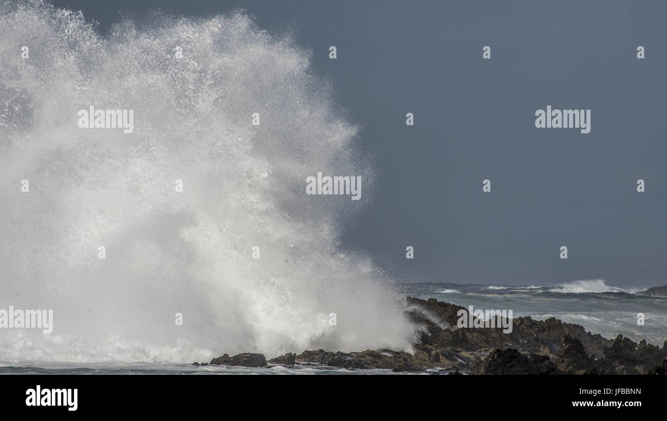 Big Wave Brakes on Rocks Stock Photo