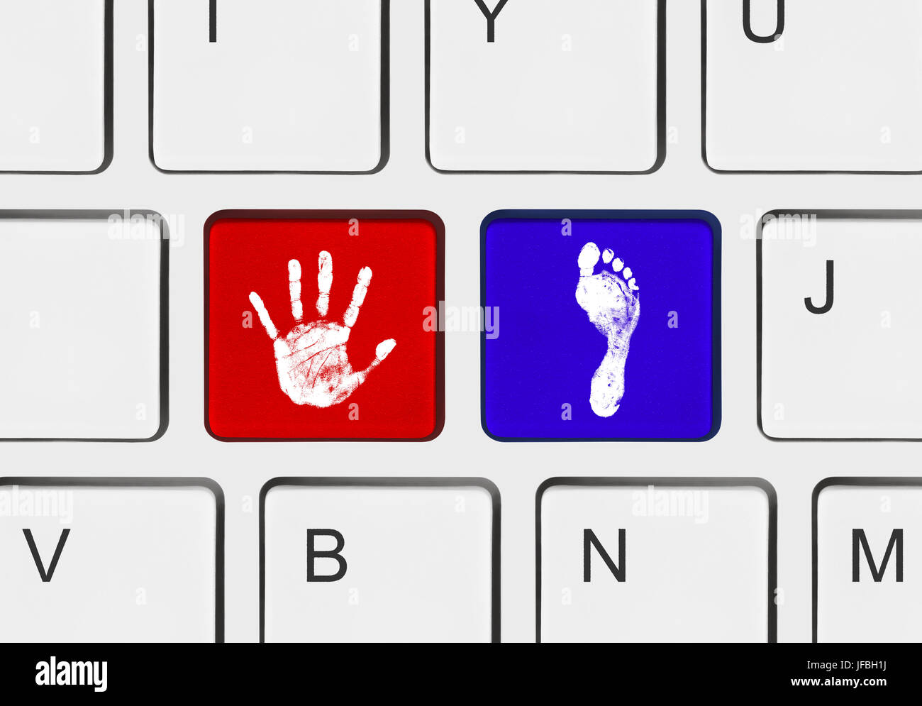 Printout of hand and foot on computer keys Stock Photo