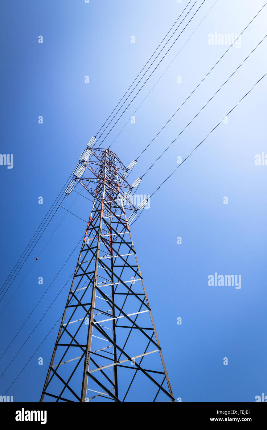 Overhead power line and a pylon against the blue sky Stock Photo - Alamy