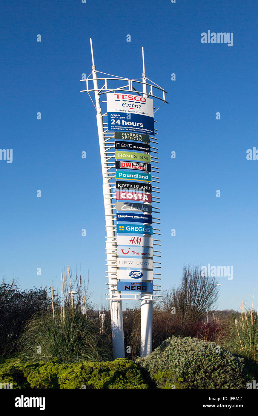 Large sign at the entrance to a shopping mall incorporating the brand names of the shops found there. Stock Photo