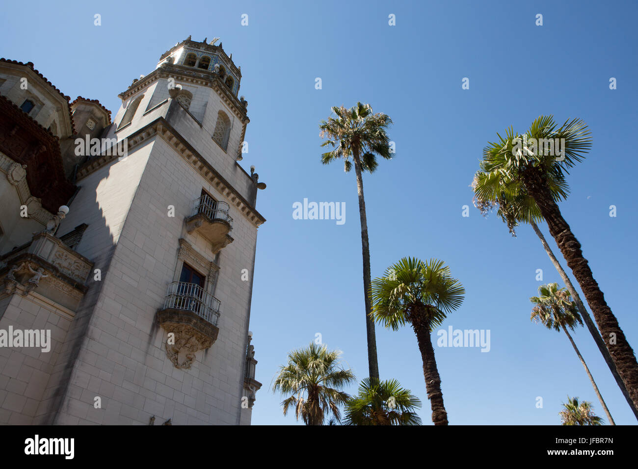 An exterior view of Hearst Castle and Casa Grande near palm trees. Stock Photo