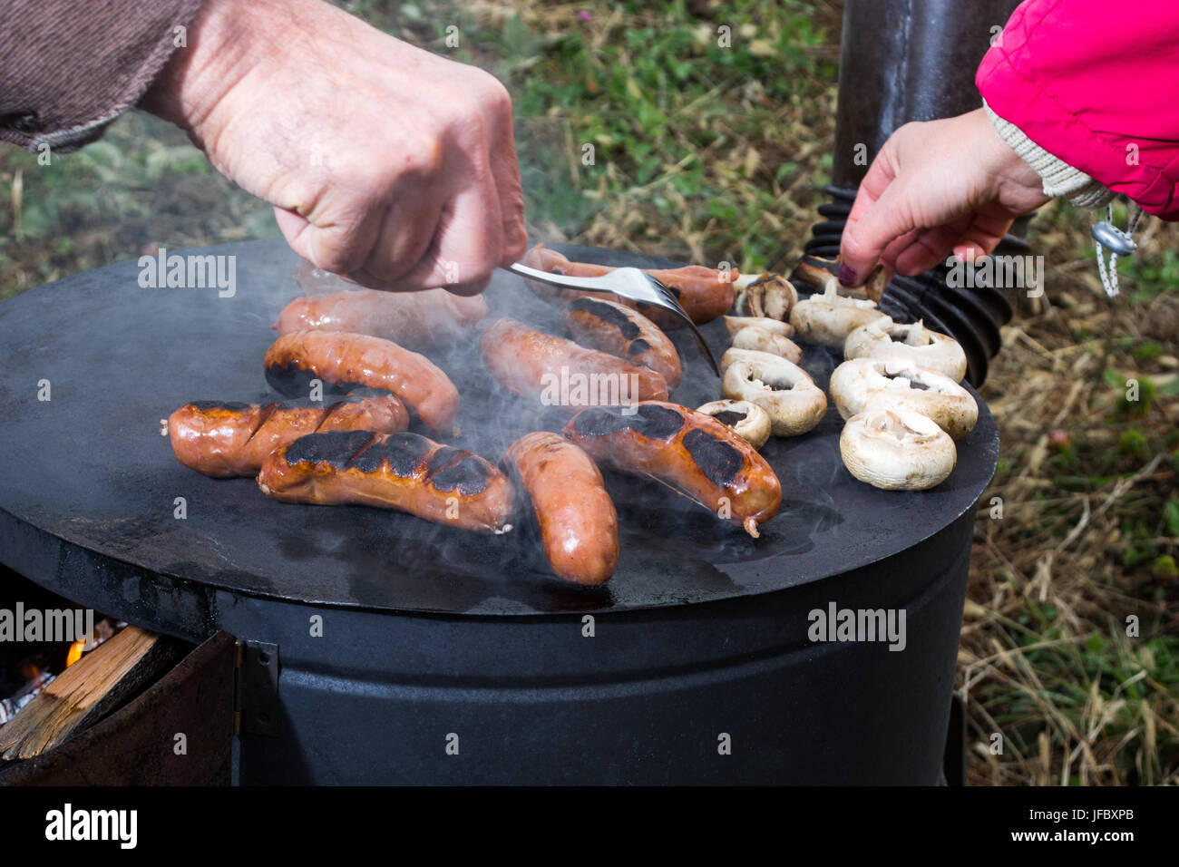 Grilling meat on wood stove Stock Photo