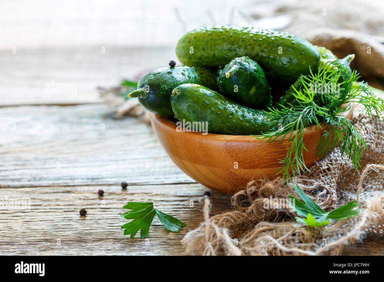 Wooden bowl with crunchy salted cucumbers. Stock Photo