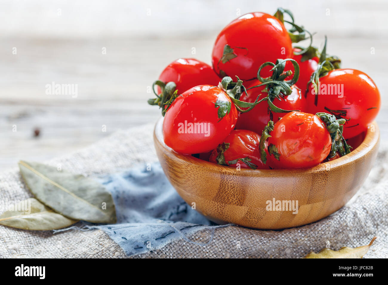 Salty cherry tomatoes in a wooden bowl Stock Photo - Alamy