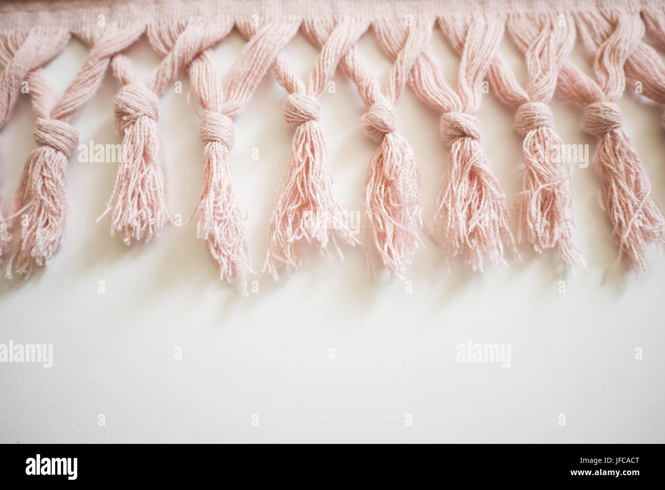 Tassels of a textile on a white background. Pink towel. Stock Photo
