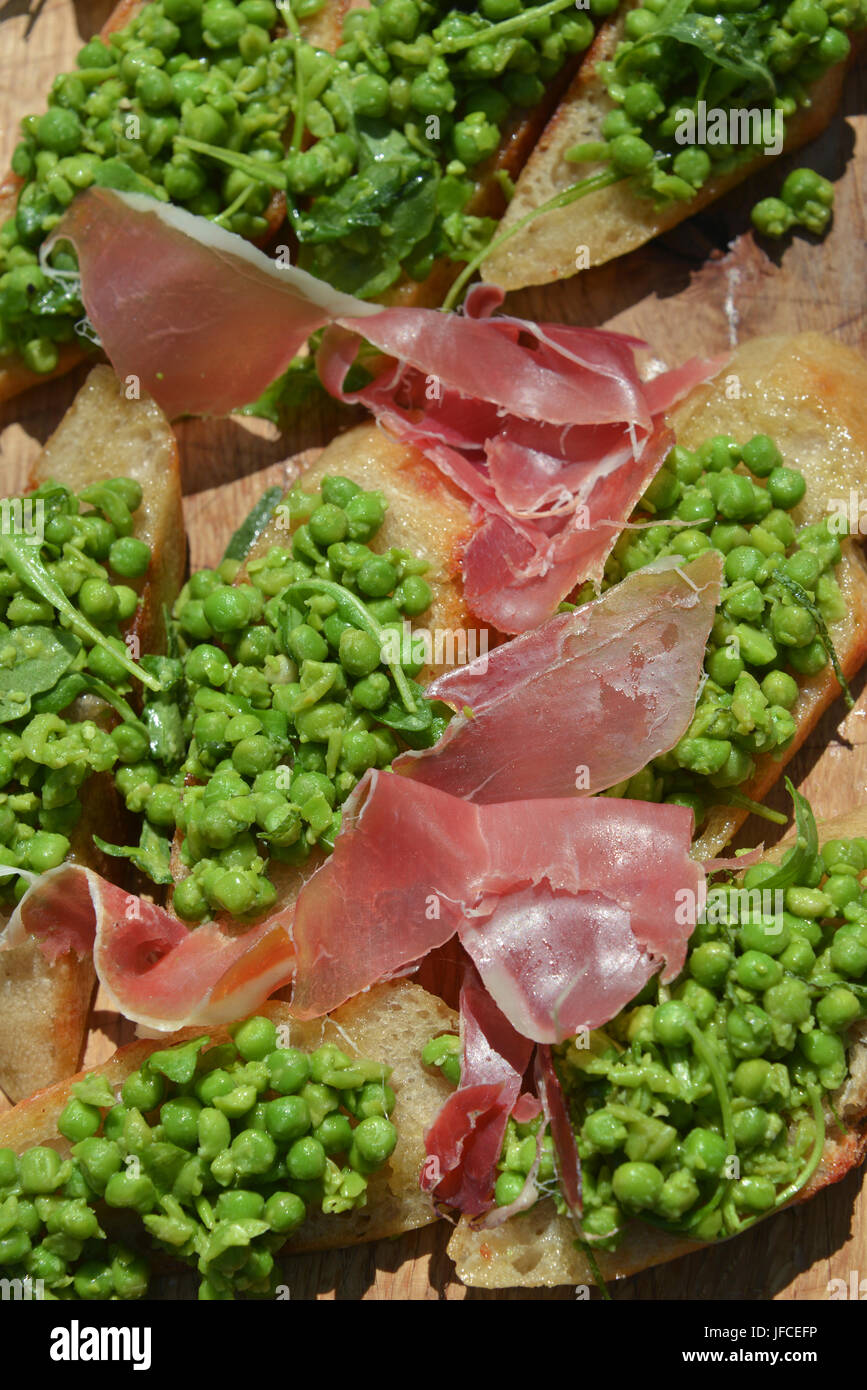 Portrait frame of Parma Ham and peas as plated meal Stock Photo