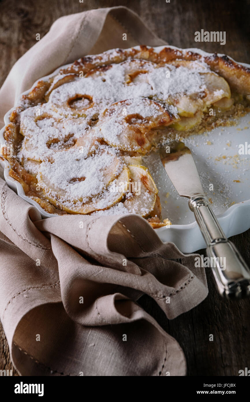 Apple pie with the knife on wooden table. Stock Photo