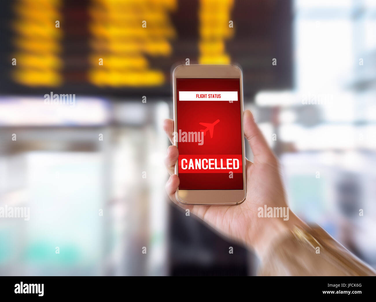 Flight cancelled. Smartphone application announces bad news to tourist. Strike or problem with plane. Woman holding mobile phone in airport terminal. Stock Photo