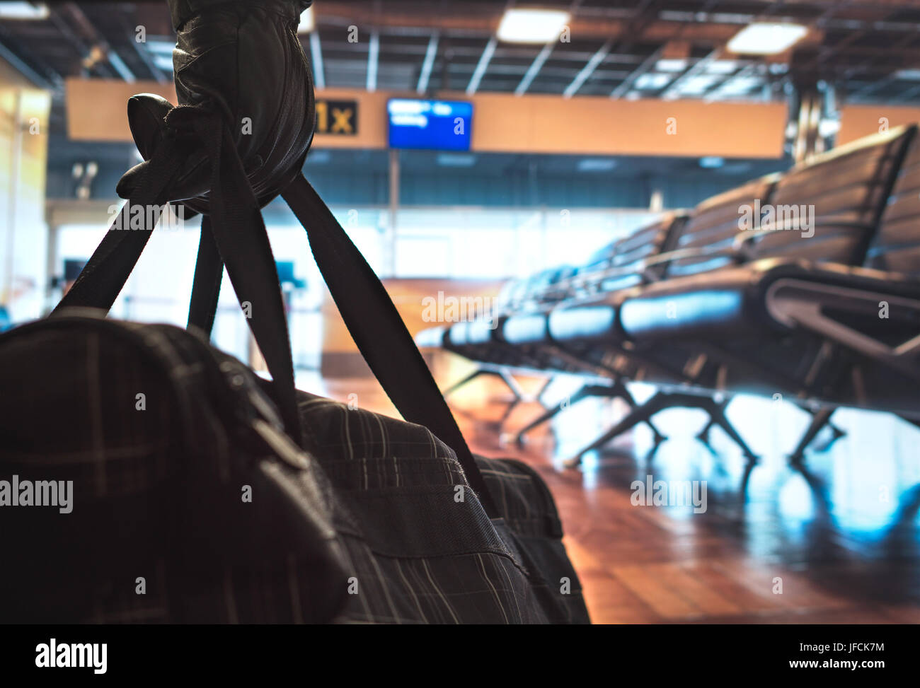 Terrorist in airport planning a bomb attack. Terrorism and security threat concept. Suspicious dangerous man in the shadows with black bag. Stock Photo