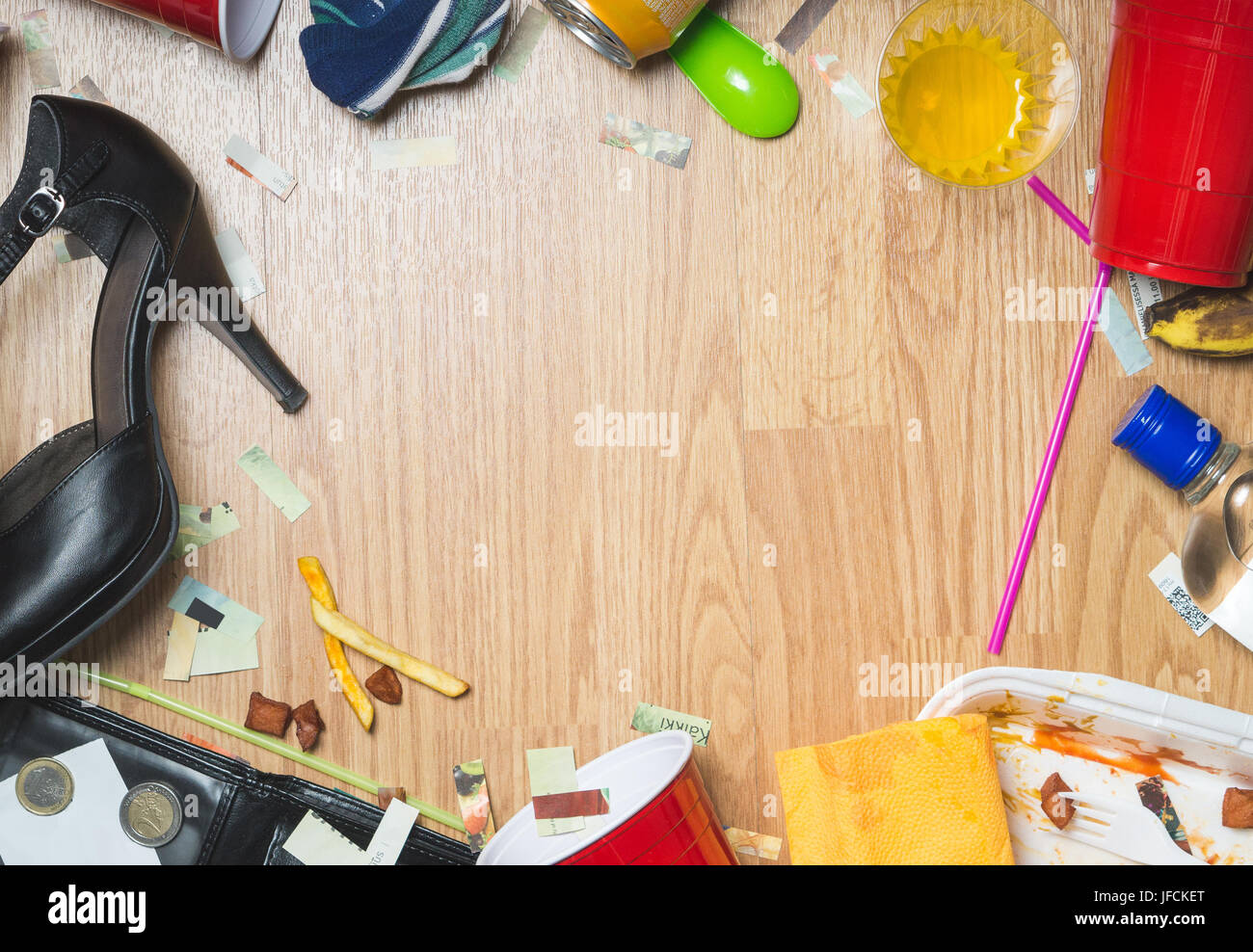After party and hangover themed background with free empty copy space for text. Wooden floor framed with drinks and trash. Stock Photo