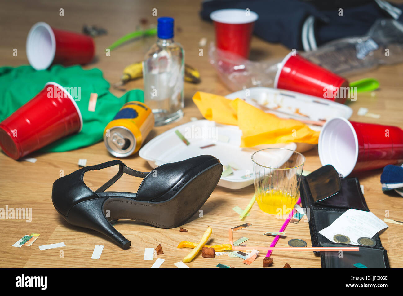 Terrible mess after party. Trash, bottles, food, cups and clothes on the floor. Messy apartment after guests leaving or the next morning. Horrible cha Stock Photo