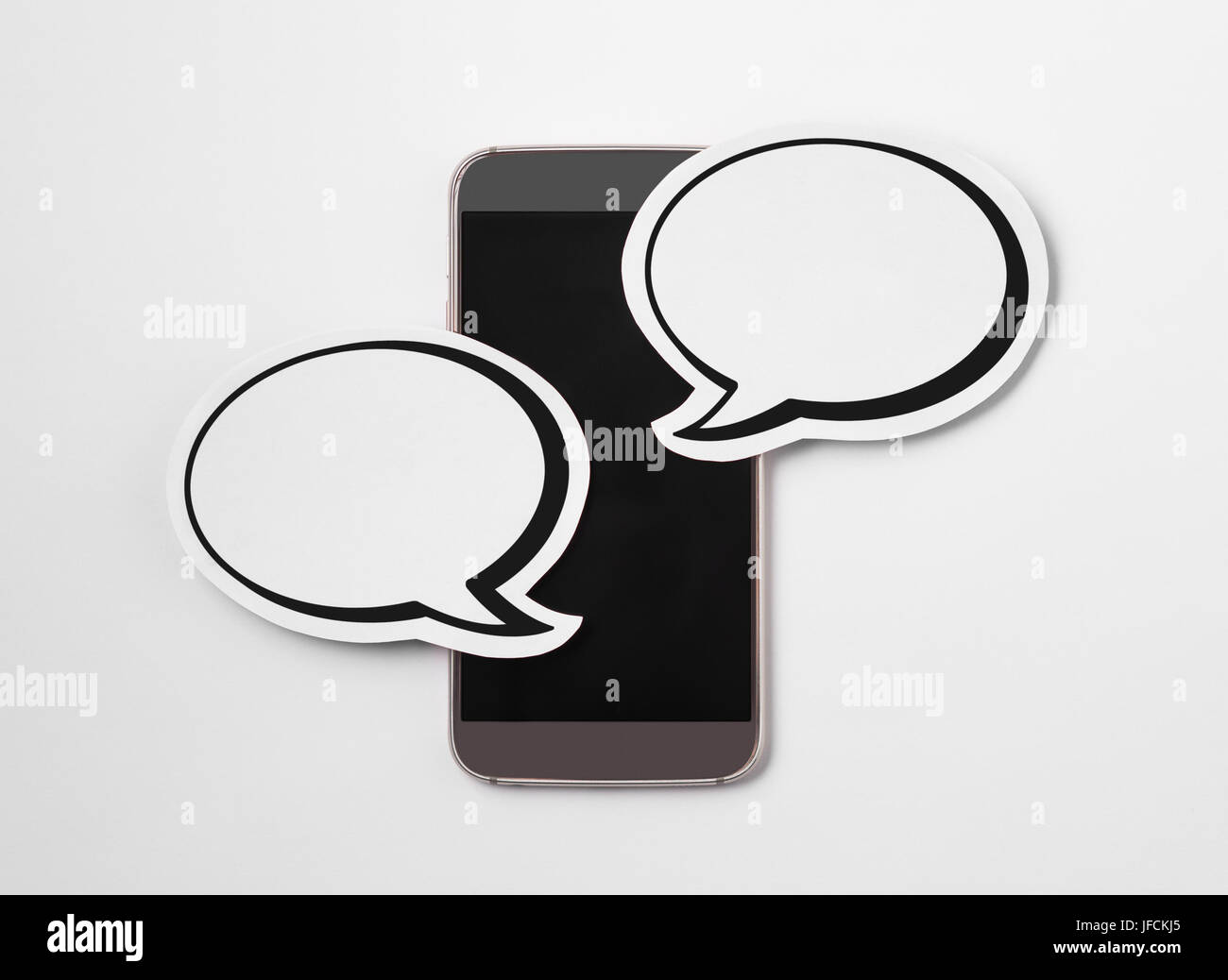 Speech bubbles on blank smartphone screen. Free copy space for text. Paper speech balloon and mobile phone on white background. Stock Photo