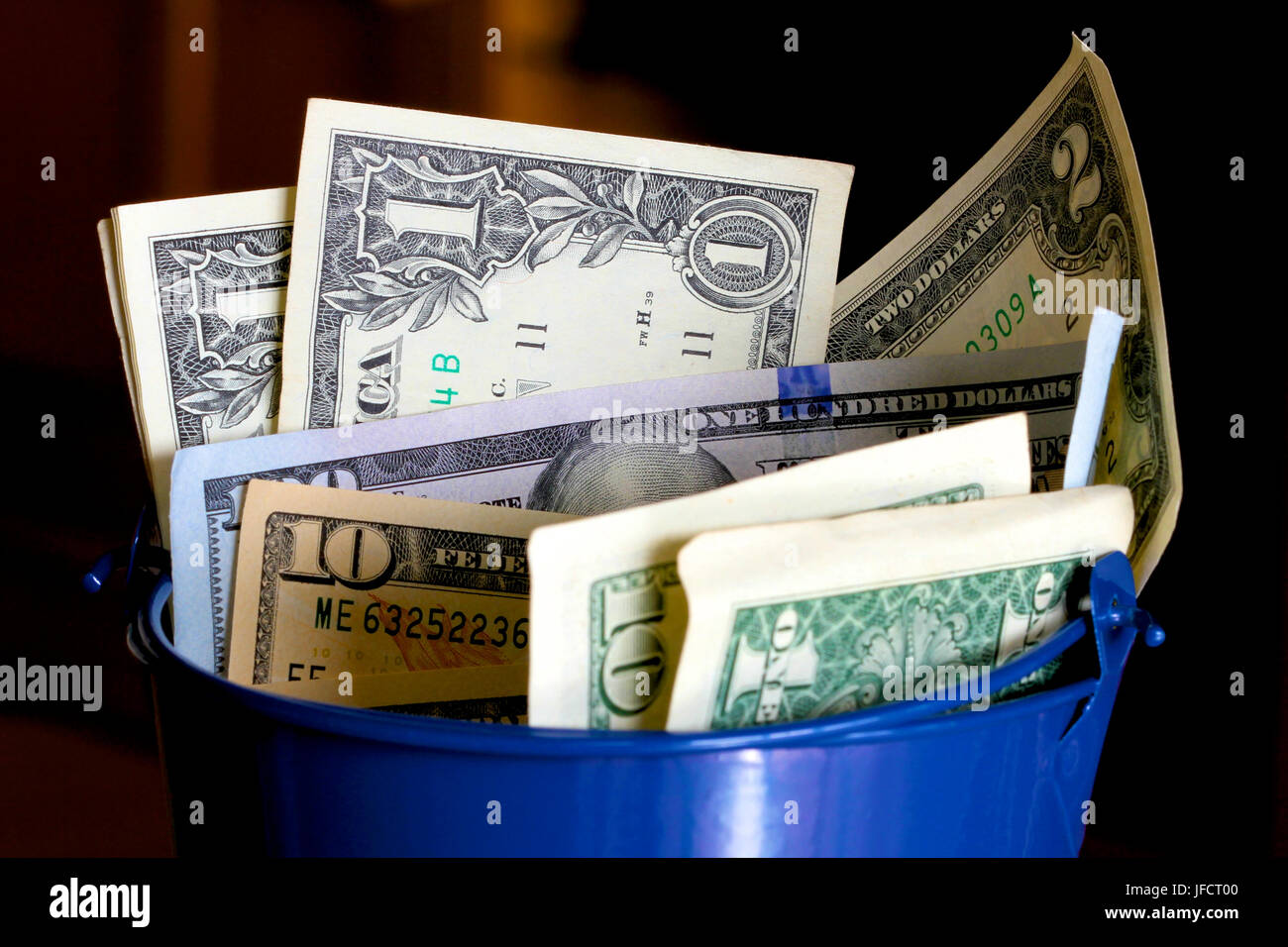 American money in a blue bucket Stock Photo Alamy