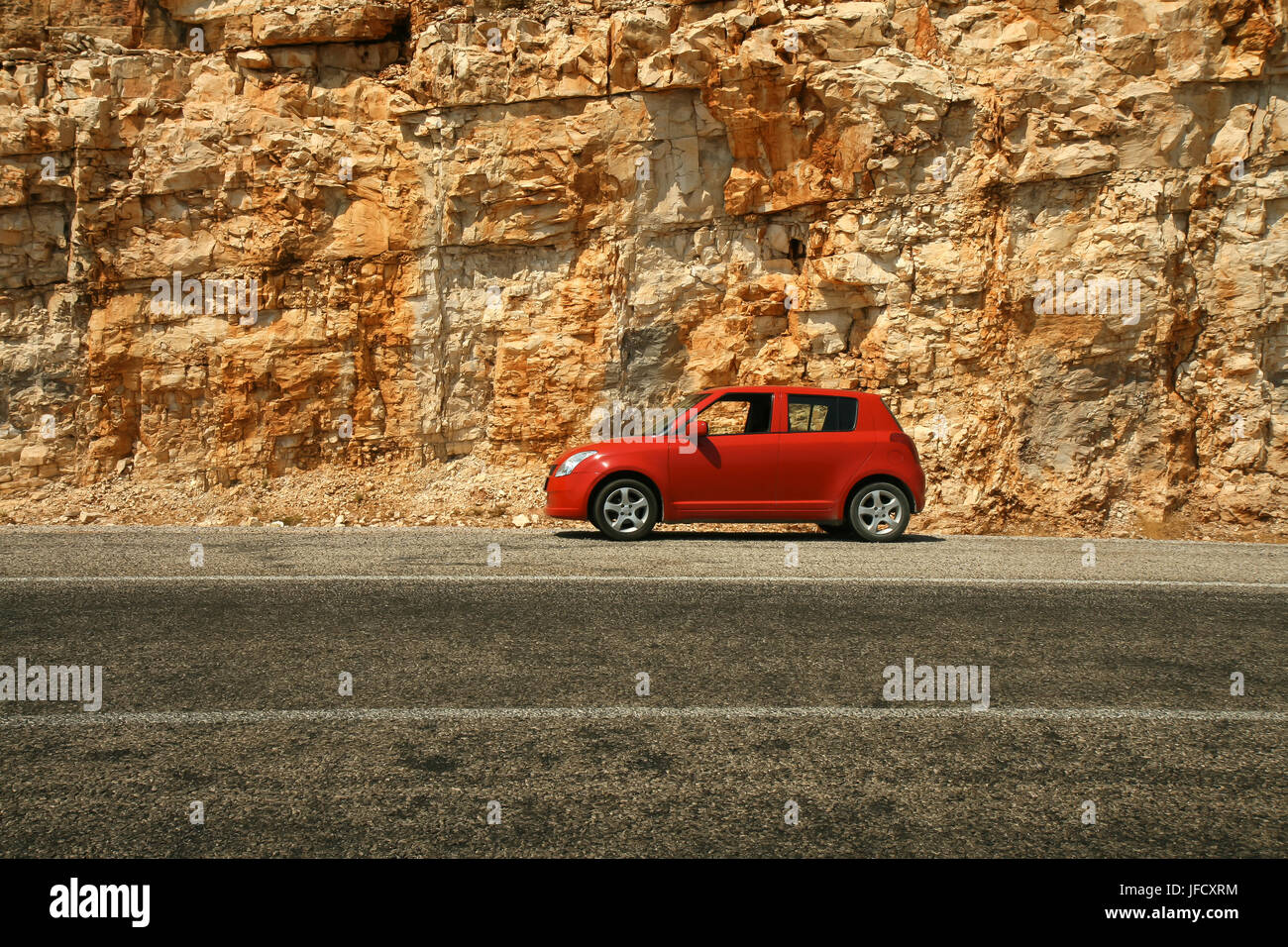 Outside View Car Rocking Small red car against a background of a vertical rock Stock Photo - Alamy