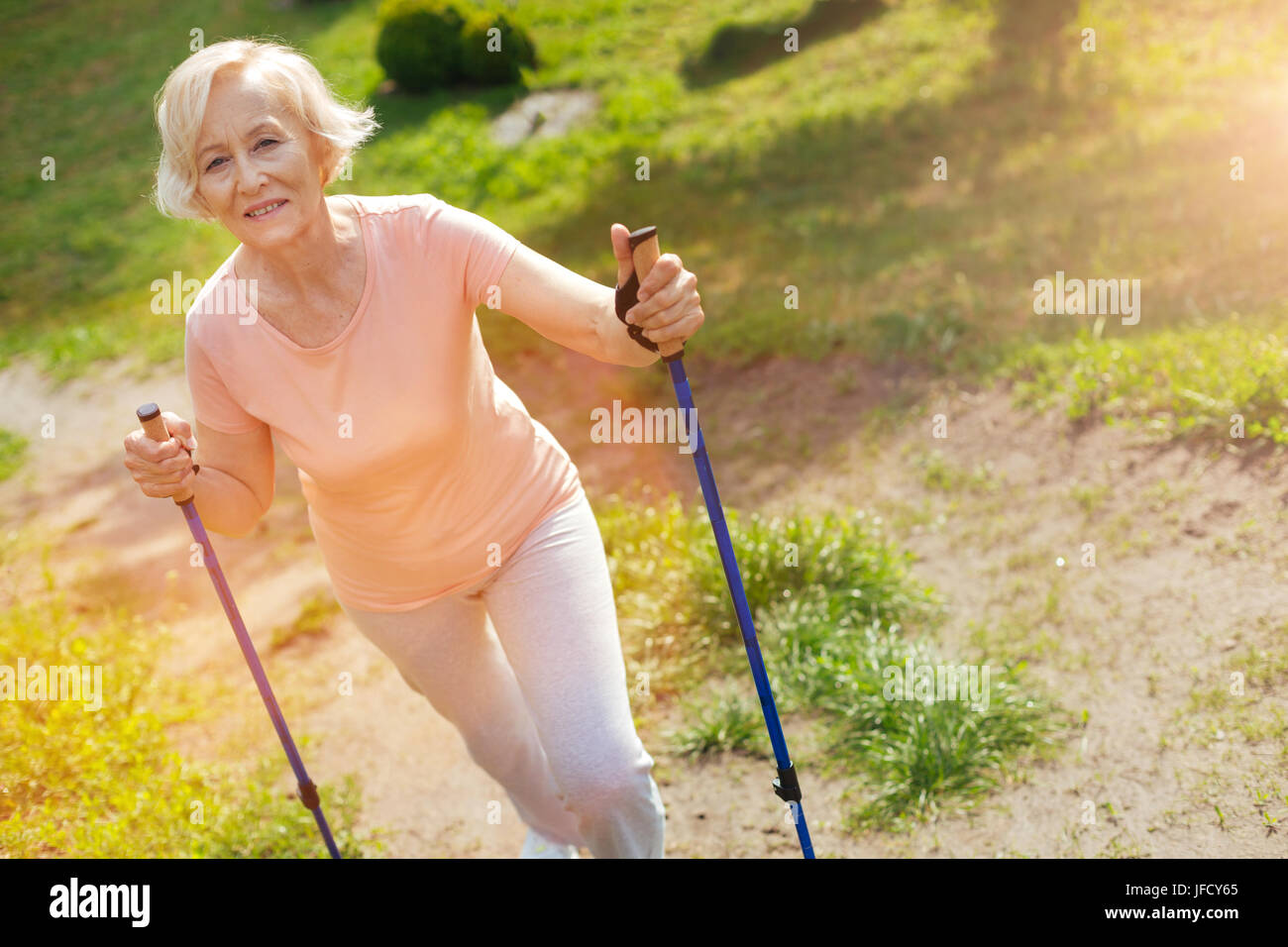 Nordic walking equipment. Happy delighted positive woman using walking