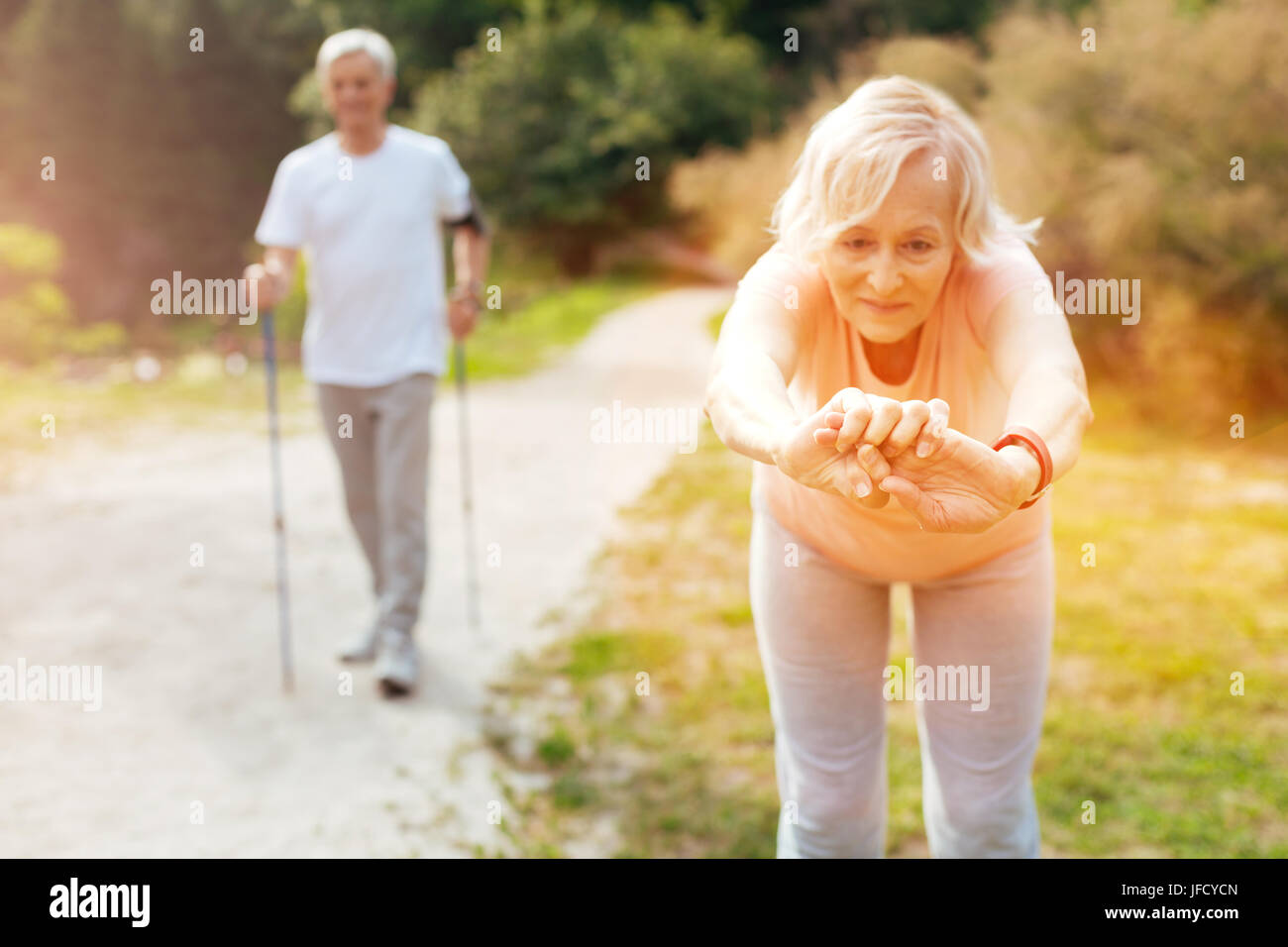 Leaning forwards. Active nice elderly woman leaning forward and looking