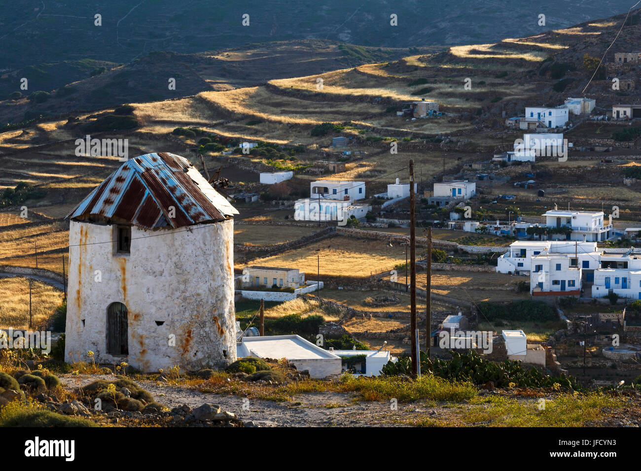 Old windmill and Chora village on Kimolos island in Greece. Stock Photo