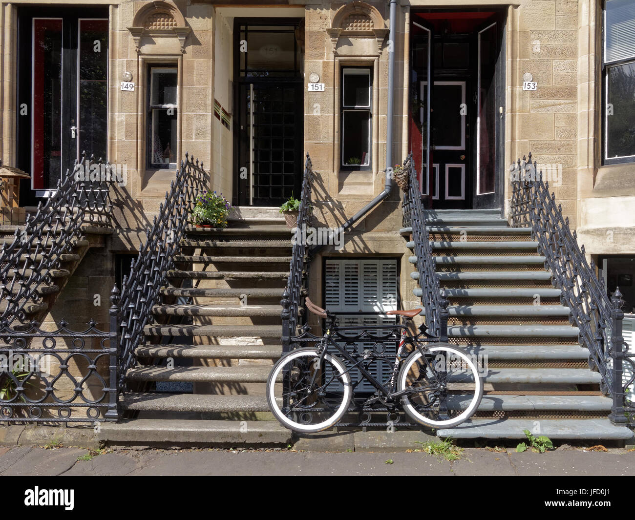 Glasgow tenements life background blond sandstone entrances upmarket with graphic bike at bottom of stairs Stock Photo