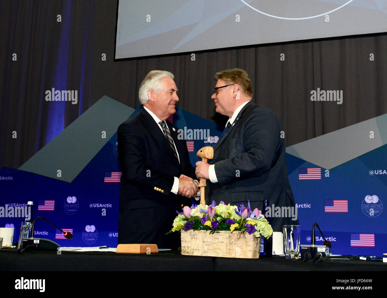 U.S. Secretary of State Rex Tillerson passes the Chairmanship gavel to Finnish Foreign Minister Timo Soini during the 10th Arctic Council Ministerial Meeting in Fairbanks, Alaska, on May 11, 2017. [U.S. Air Force photo / ] Stock Photo
