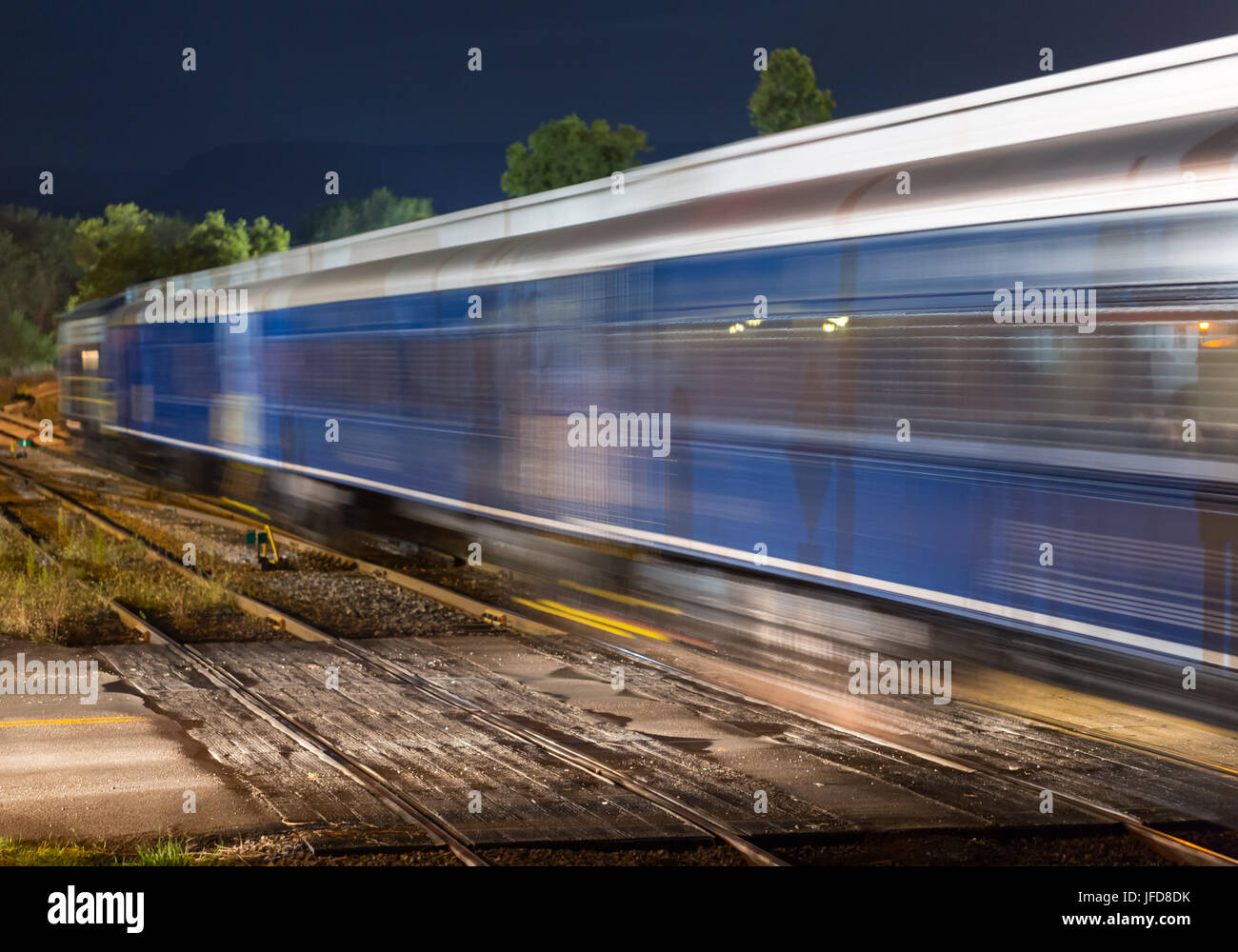 Blue coaches of train pass crossing Stock Photo