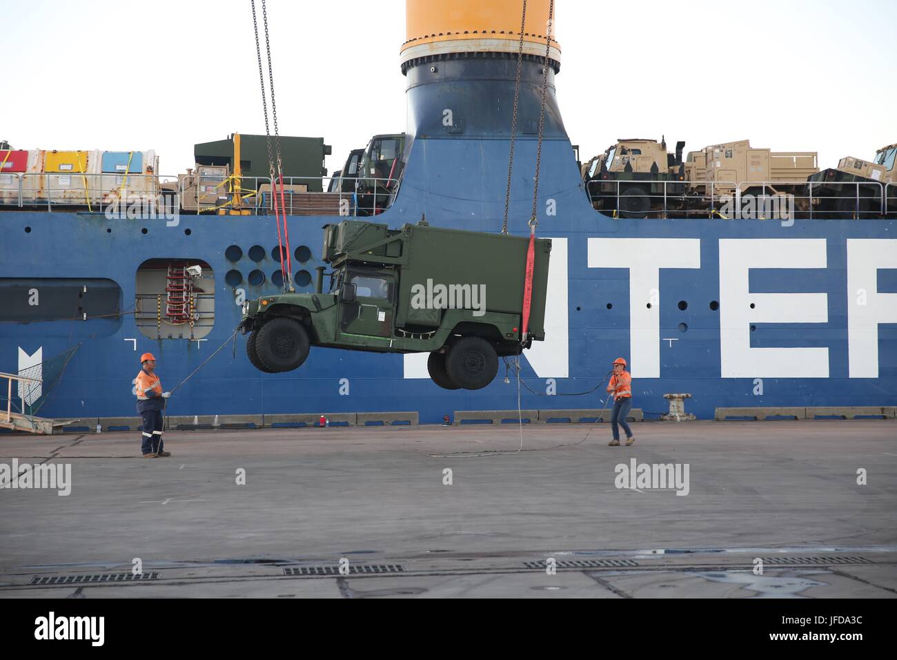 A shipboard crane offloads a vehicle from heavy-lift vessel Ocean Jazz ...