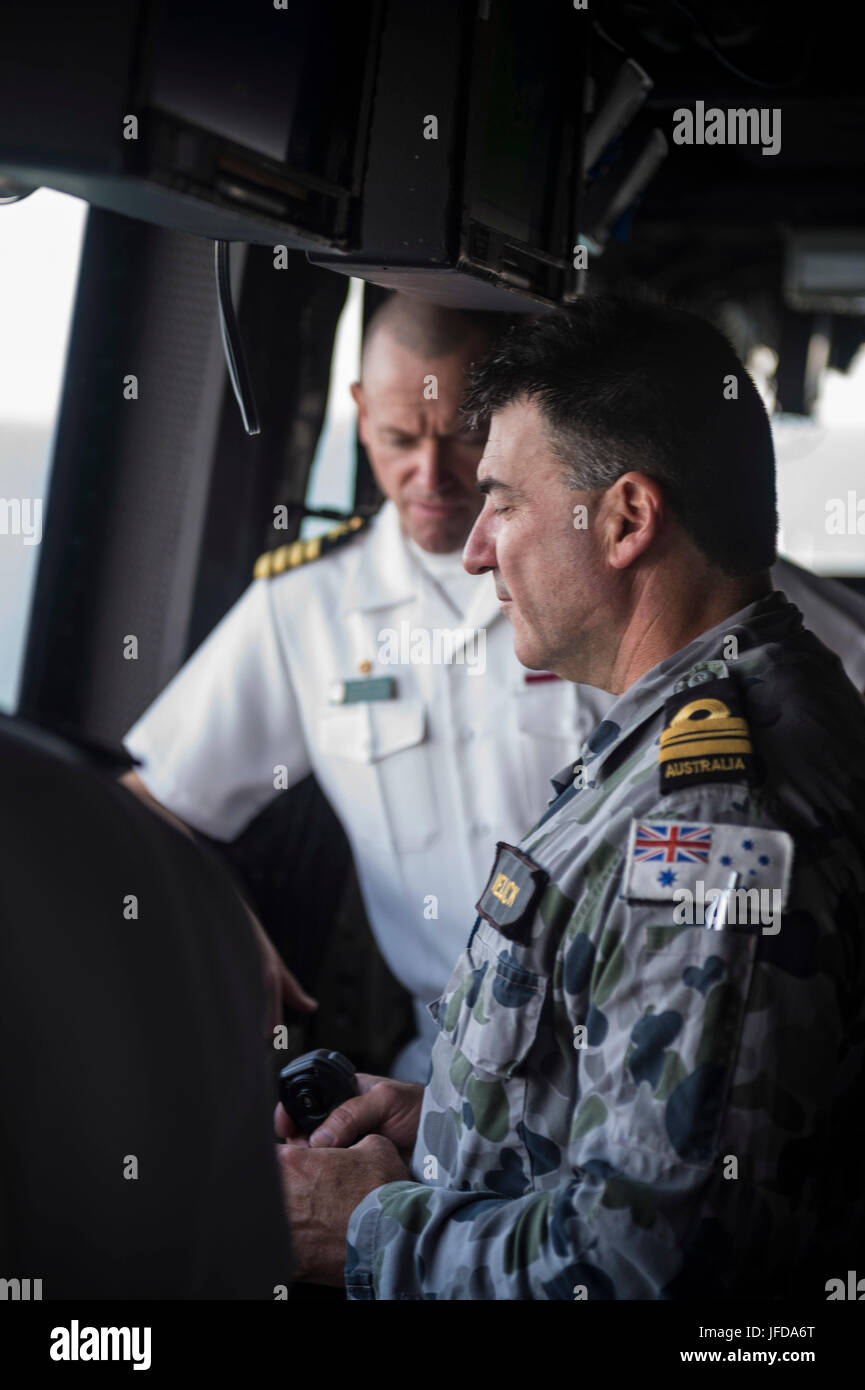 170628-N-XX123-009 CAIRNS, Australia (June 28, 2017) Cmdr. Peter Mellick, from the Royal Australian Navy, and Capt. Nate Moyer, commanding officer of the amphibious transport dock USS Green Bay (LPD 20), discuss ship maneuvers during a sea and anchor detail. Green Bay, part of the Bonhomme Richard Expeditionary Strike Group, is operating in the Indo-Asia-Pacific region to enhance partnerships and be a ready-response force for any type of contingency. (U.S. Navy photo by Lt. j.g. Zachary Fuller/Released) Stock Photo