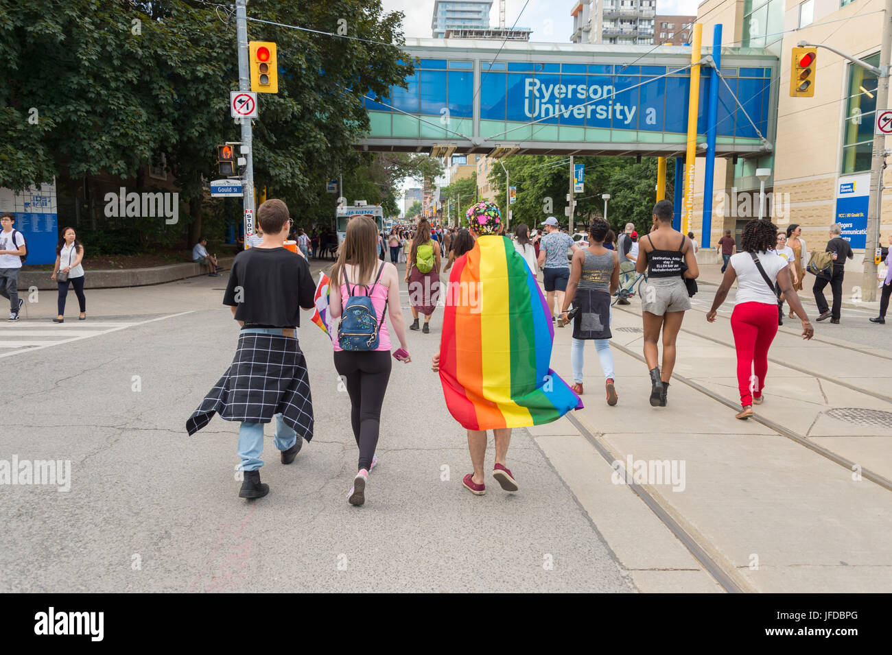 Toronto, CA - 25 June 2017: a young man with a rainbow gay flag on his back is walking in gay village Stock Photo