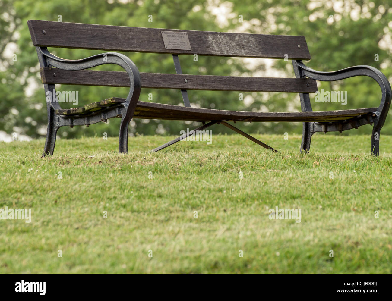 Wooden bench in a park in Bristol Stock Photo