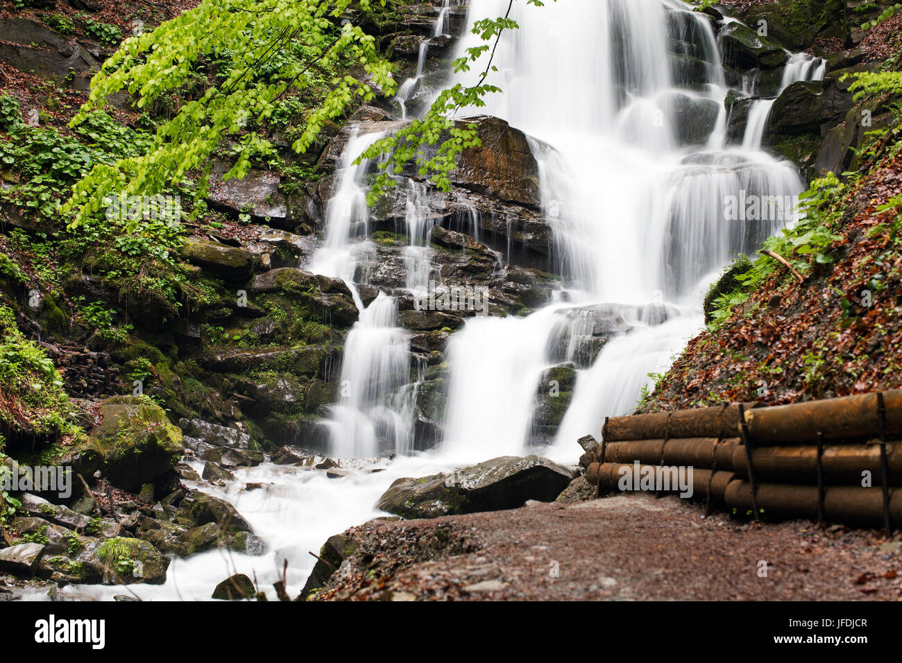 The rapid flow of water falls strongly from the height of the Carpathian mountain. Stock Photo