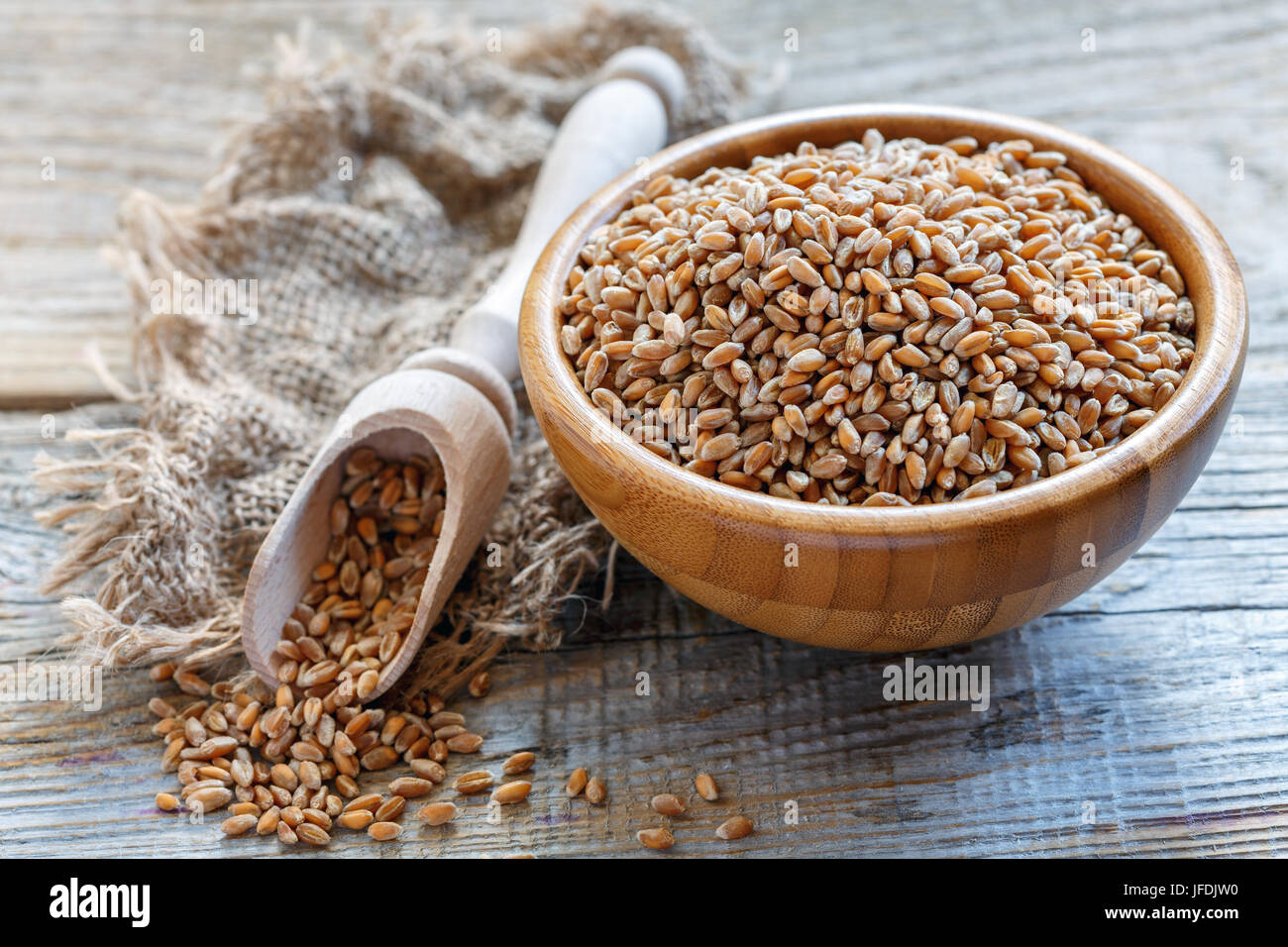 Wooden bowl and scoop wheat. Stock Photo