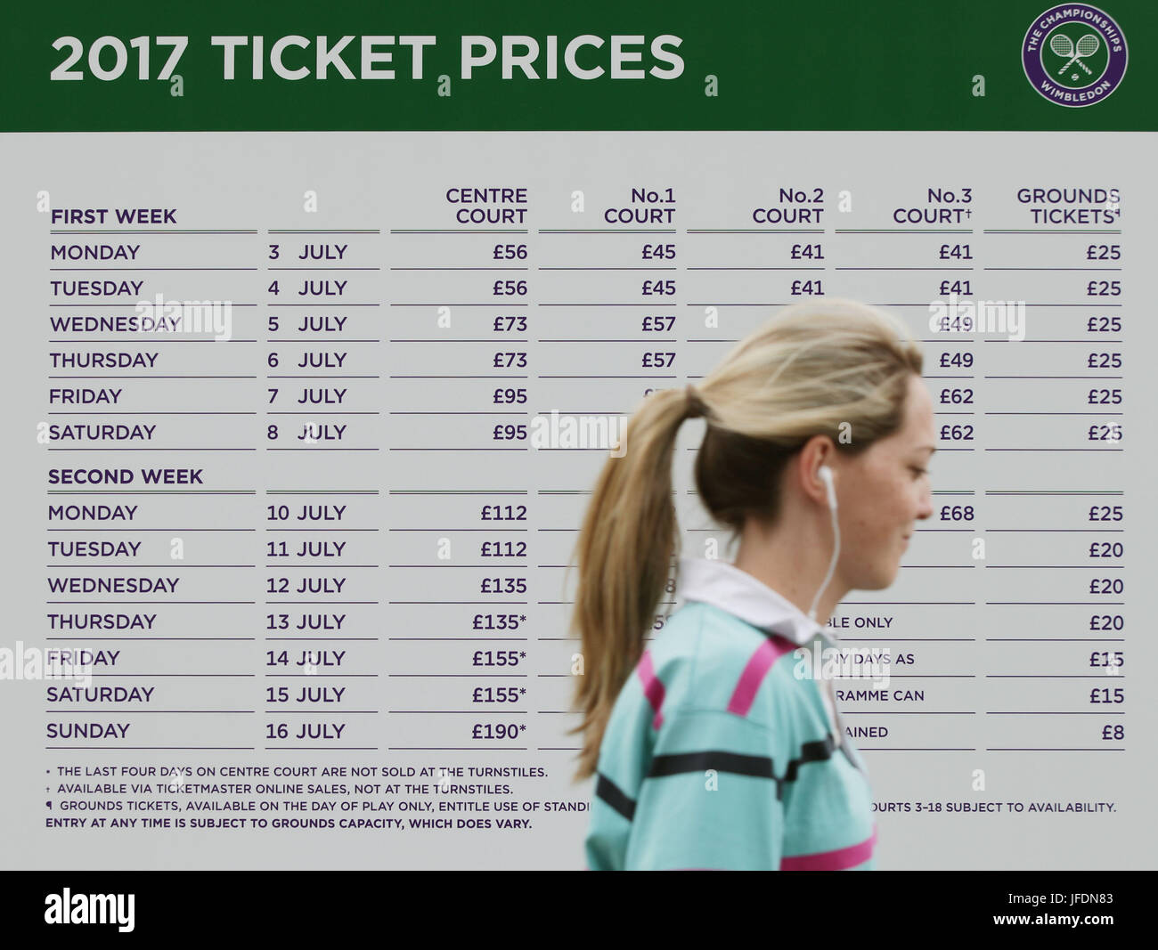 A woman walks past a sign detailing ticket prices outside the All England  Tennis Club, ahead of the Wimbledon tennis tournament in southwest London  Stock Photo - Alamy