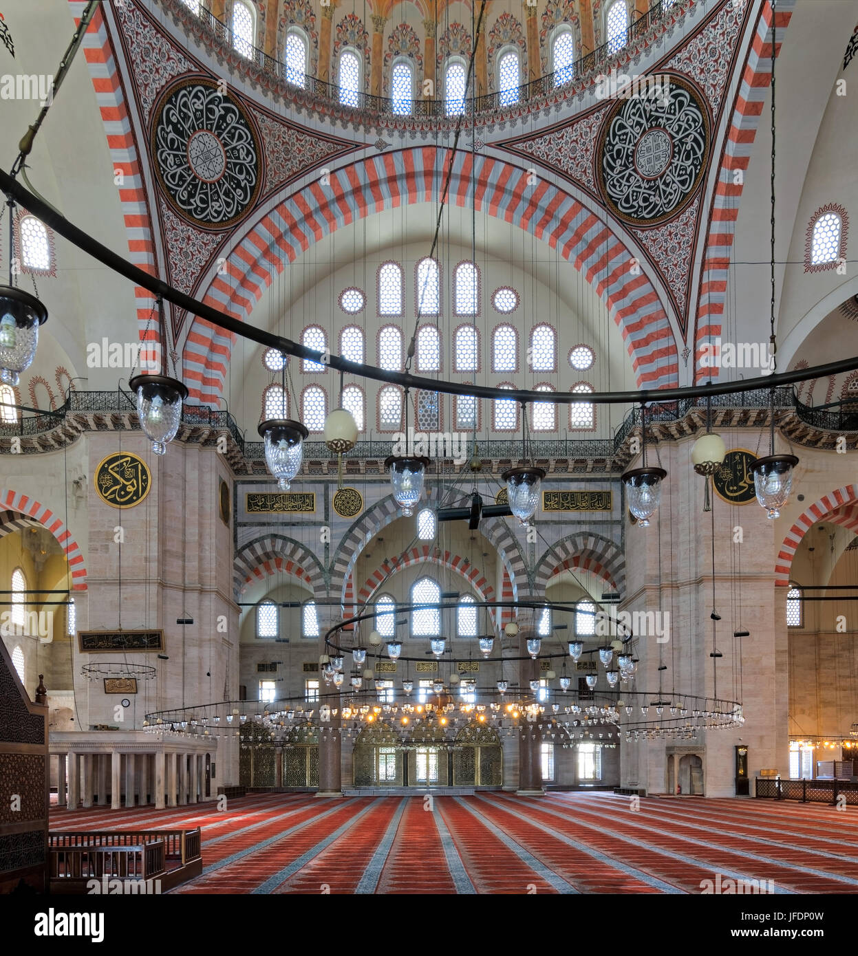 Interior of Suleymaniye Mosque, an Ottoman Baroque style mosque completed in 1755, with huge arches & many colored stained glass windows, Fatih distri Stock Photo