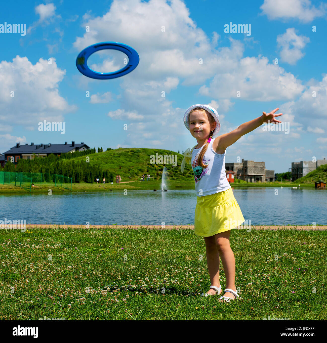 little girl throws a plate in the meadow Stock Photo Alamy