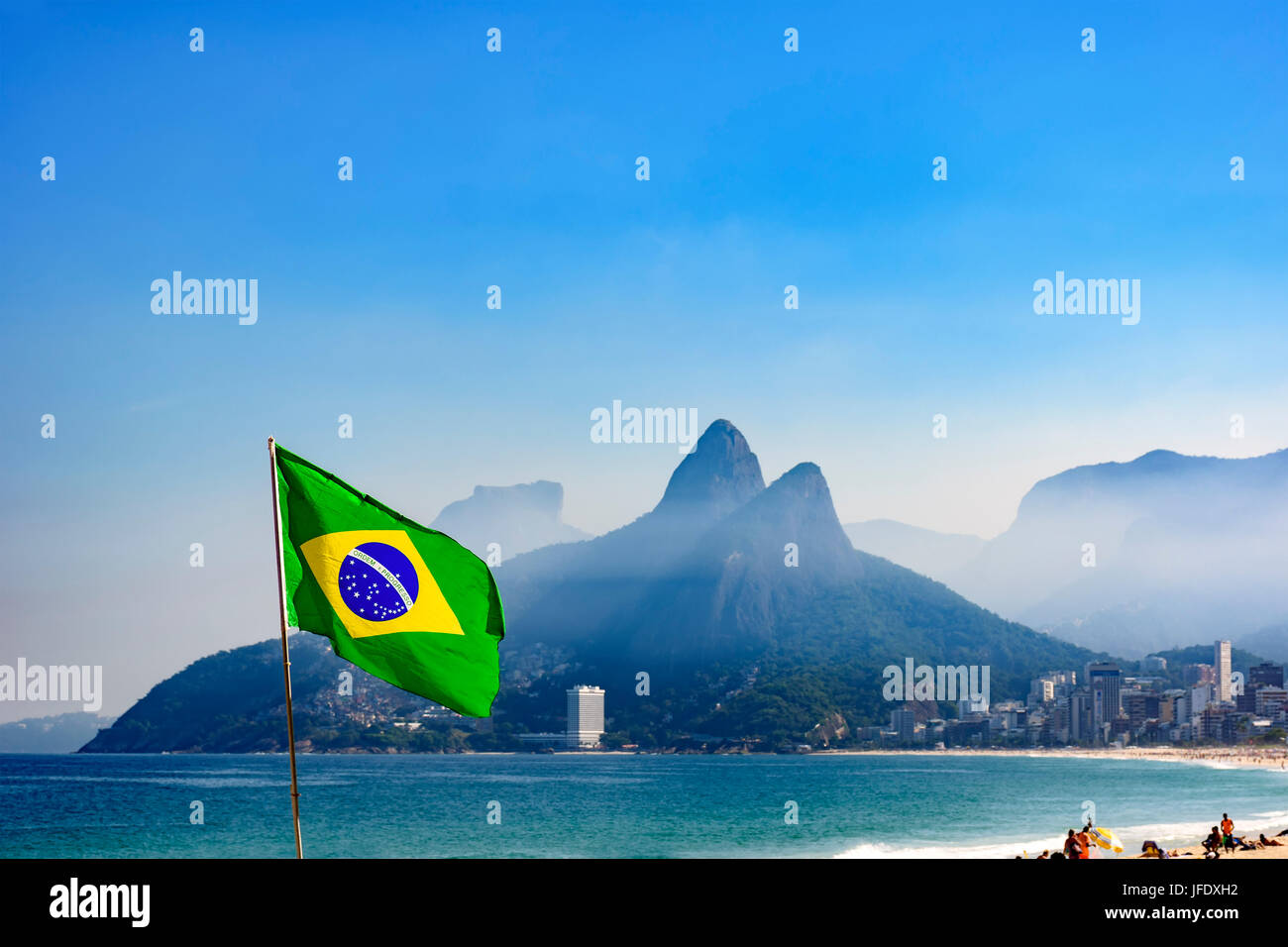Brazilian flag at Ipanema beach in Rio de Janeiro with Two Brothers hill and Gavea stone in background Stock Photo