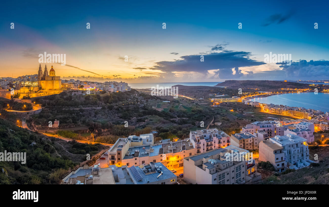 Il-Mellieha, Malta - Beautiful panoramic skyline view of Mellieha town at blue hour with Paris Church and Mellieha beach and Gozo at background with b Stock Photo