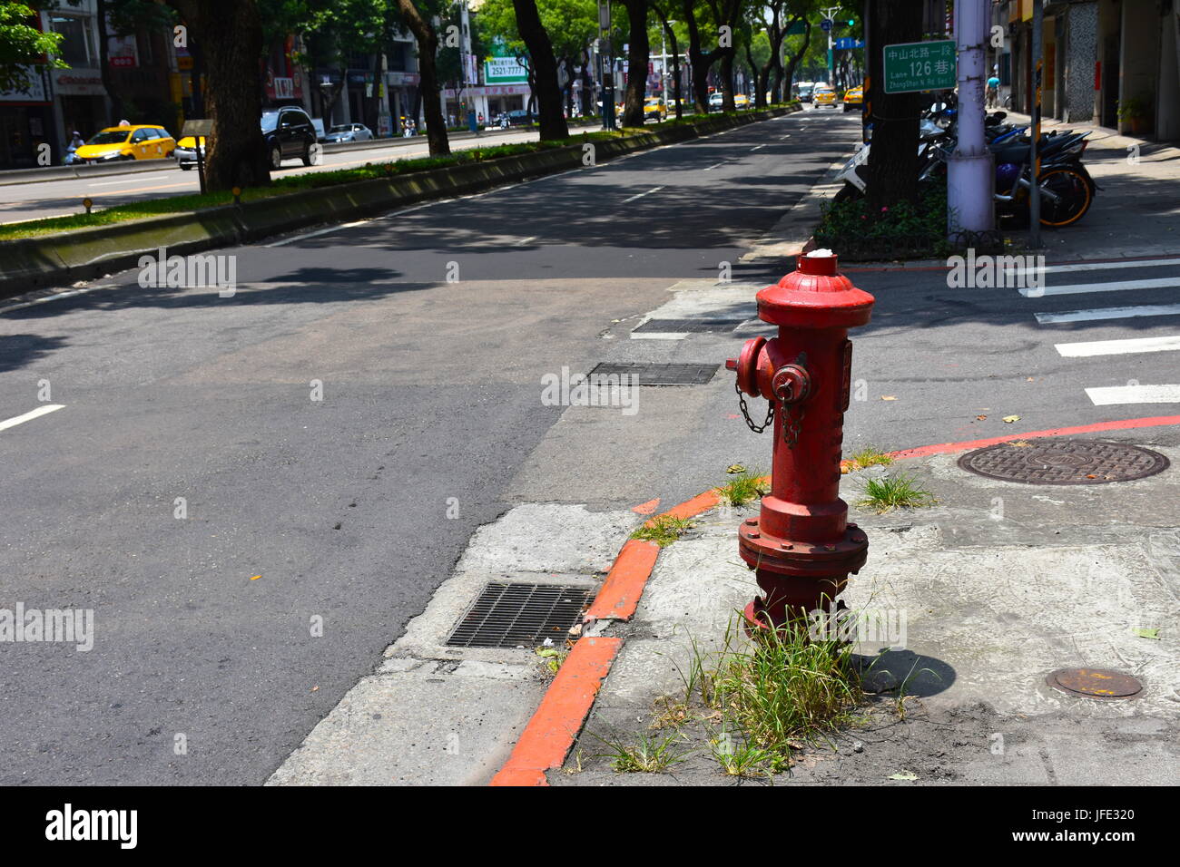 A fire hydrant on the side of the road on a corner in Taipei, Taiwan. Stock Photo