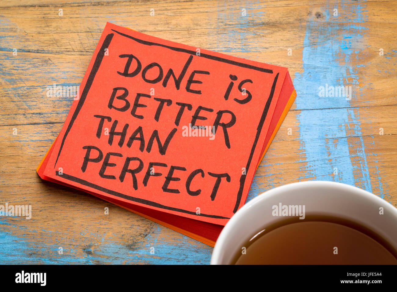 Done is better than perfect reminder - handwriting in black ink on colorful sticky notes against rustic wood Stock Photo