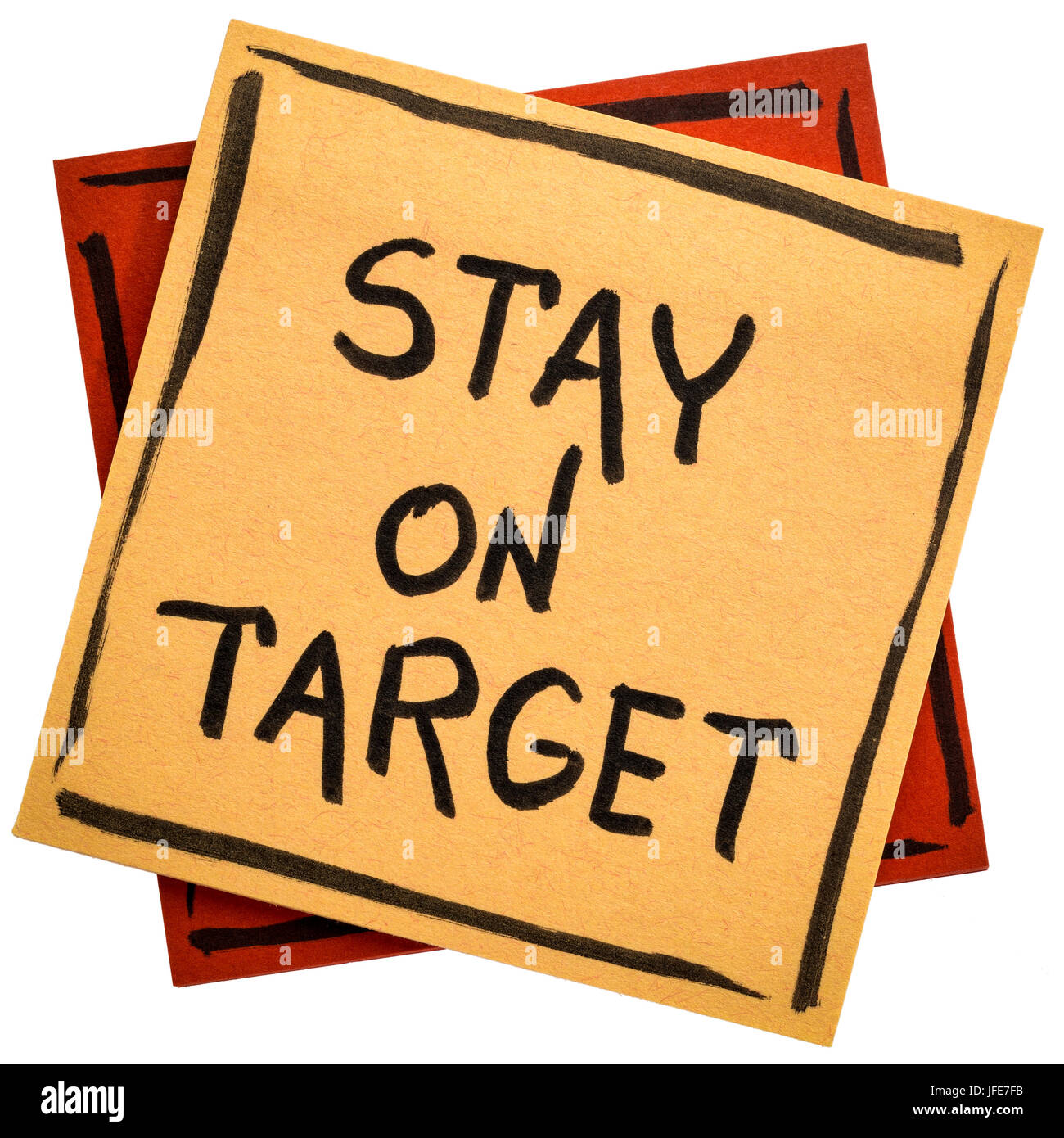 Stay on target - handwriting in black ink on an isolated sticky note Stock Photo