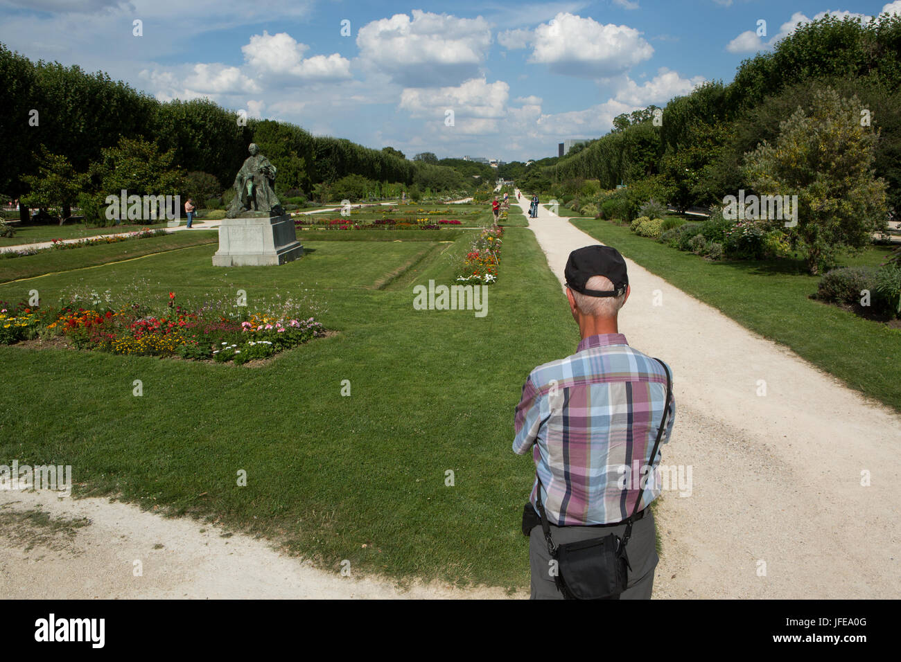 A man stands and observes the botanical garden Jardin des Plantes. Stock Photo