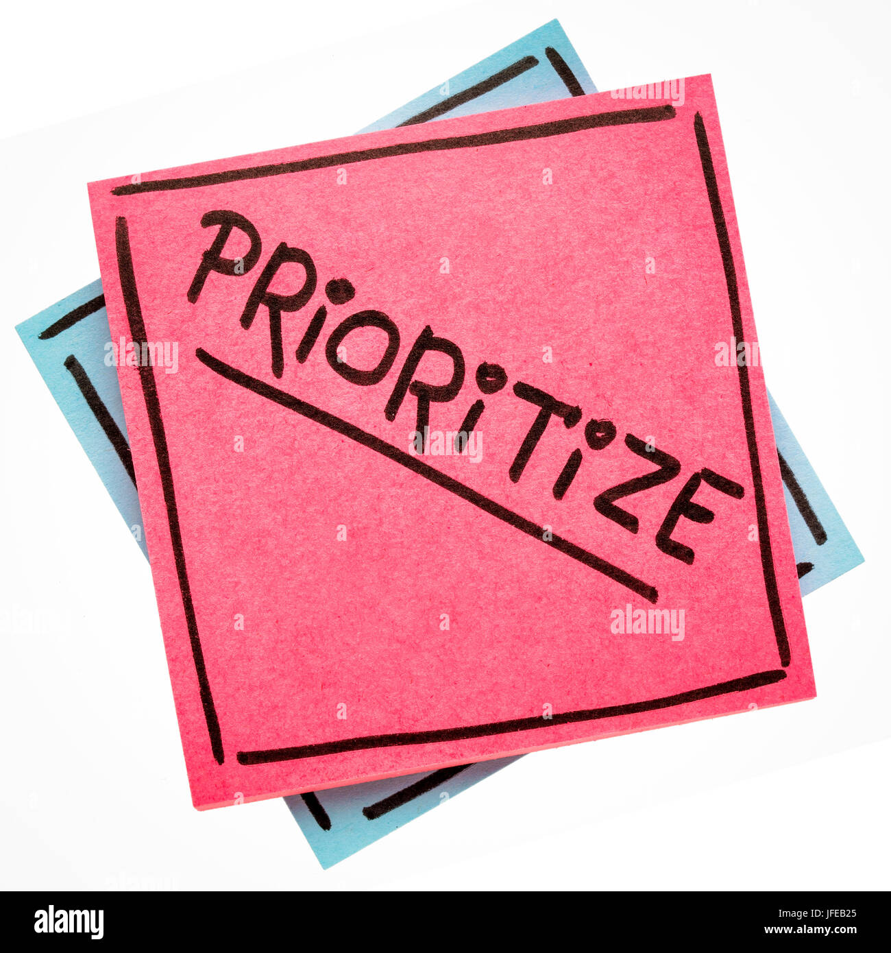 prioritize advice or reminder - handwriting on an isolated sticky note Stock Photo