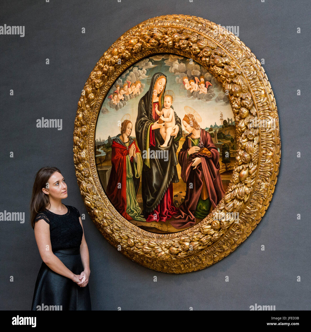 London, UK. 30 June 2017. A Christie's employee looks at The Madonna and Child with Sains Mary Magdalene and Catherine, by The Master of Memphis, est. GBP 200,000-300,000. Christie's present highlights from their forthcoming Old Masters Evening Sale on 6 July 2017 during Christie's Classic Week. Stock Photo