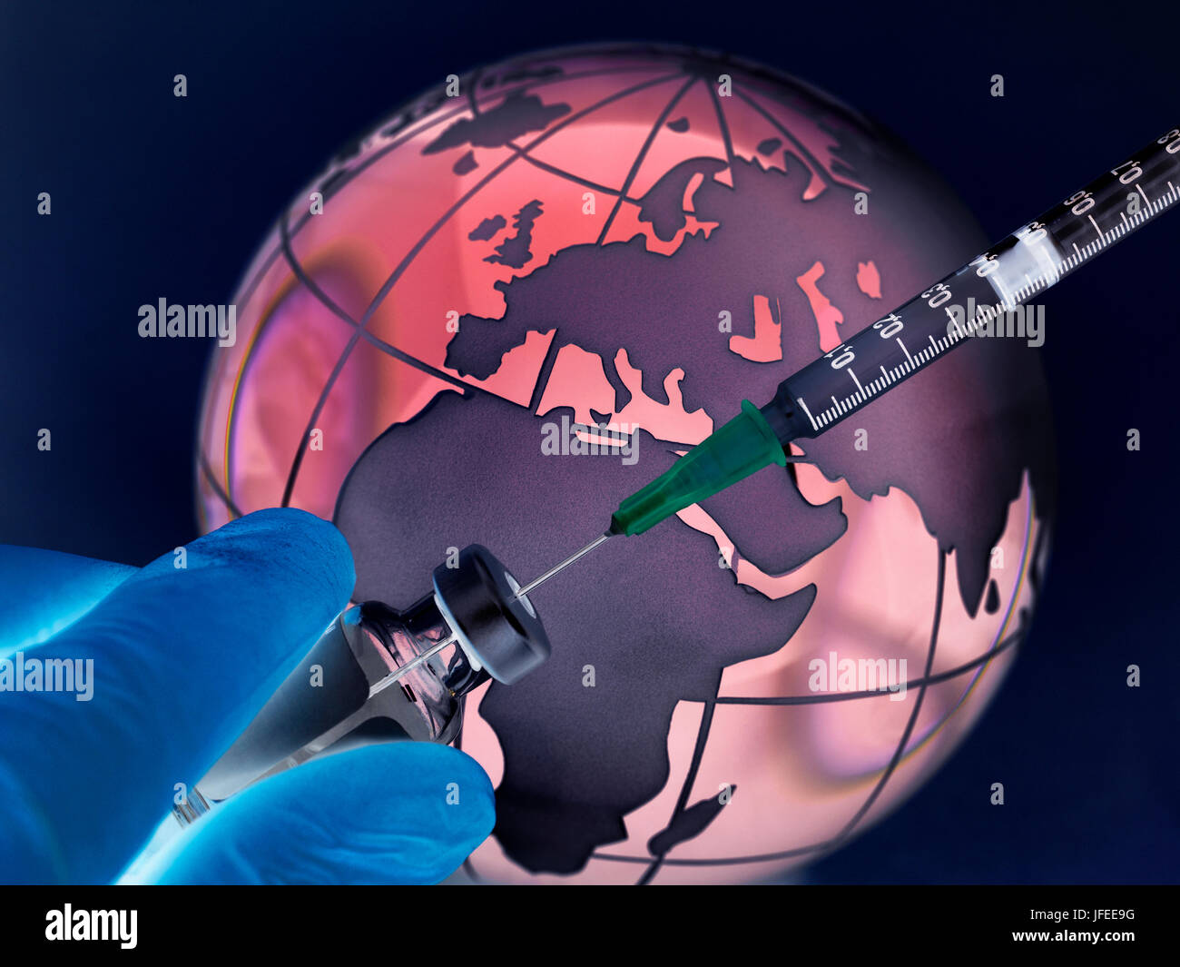 A globe with syringe and medicine to illustrate a cure for a worldwide pandemic. Stock Photo