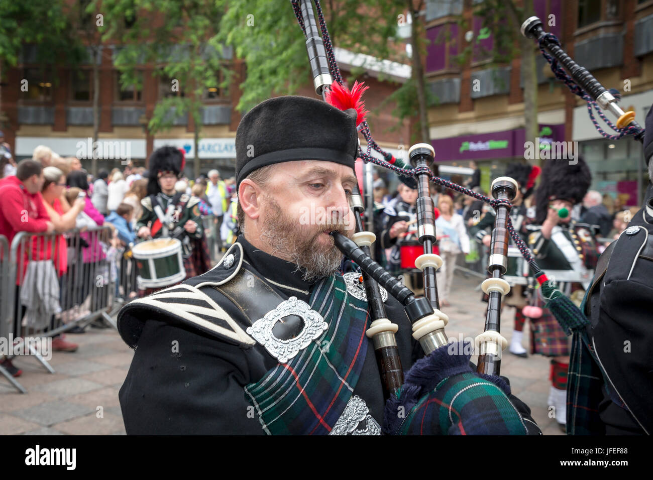 Close up of a piper in the Northenden Pipe Band marching through the town centre on Warrington Walking Day Stock Photo