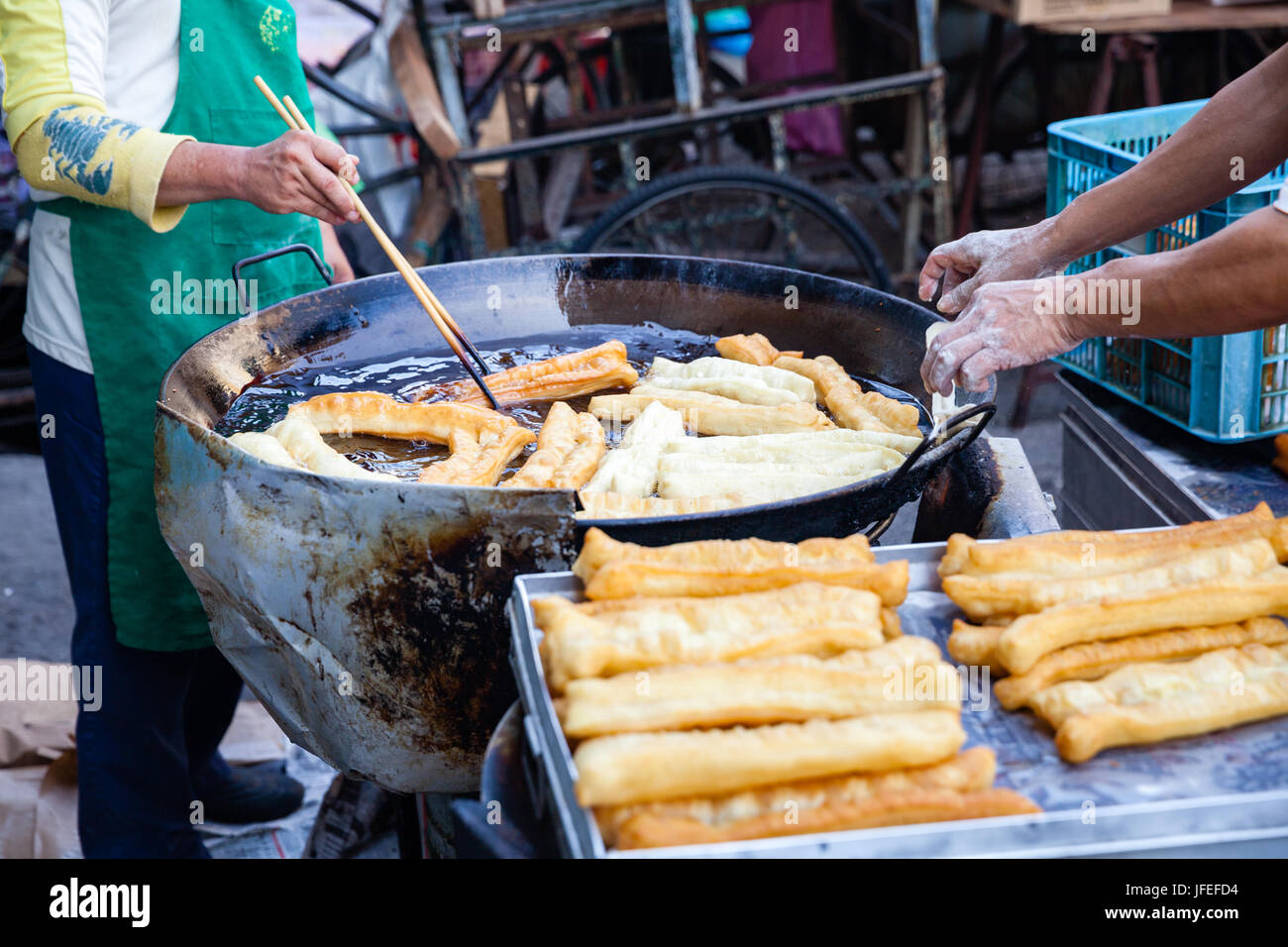 GEORGE TOWN, MALAYSIA - MARCH 23: Man cooks youtiao at the street market of George Town on March 23, 2016 in George Town, Malaysia. Stock Photo