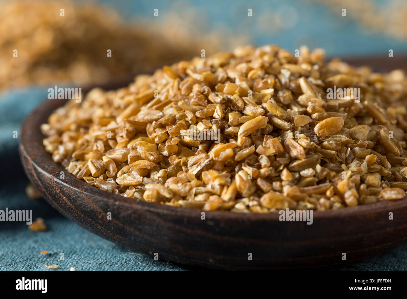 Raw Organic Brown Bulgar Wheat in a Spoon Stock Photo