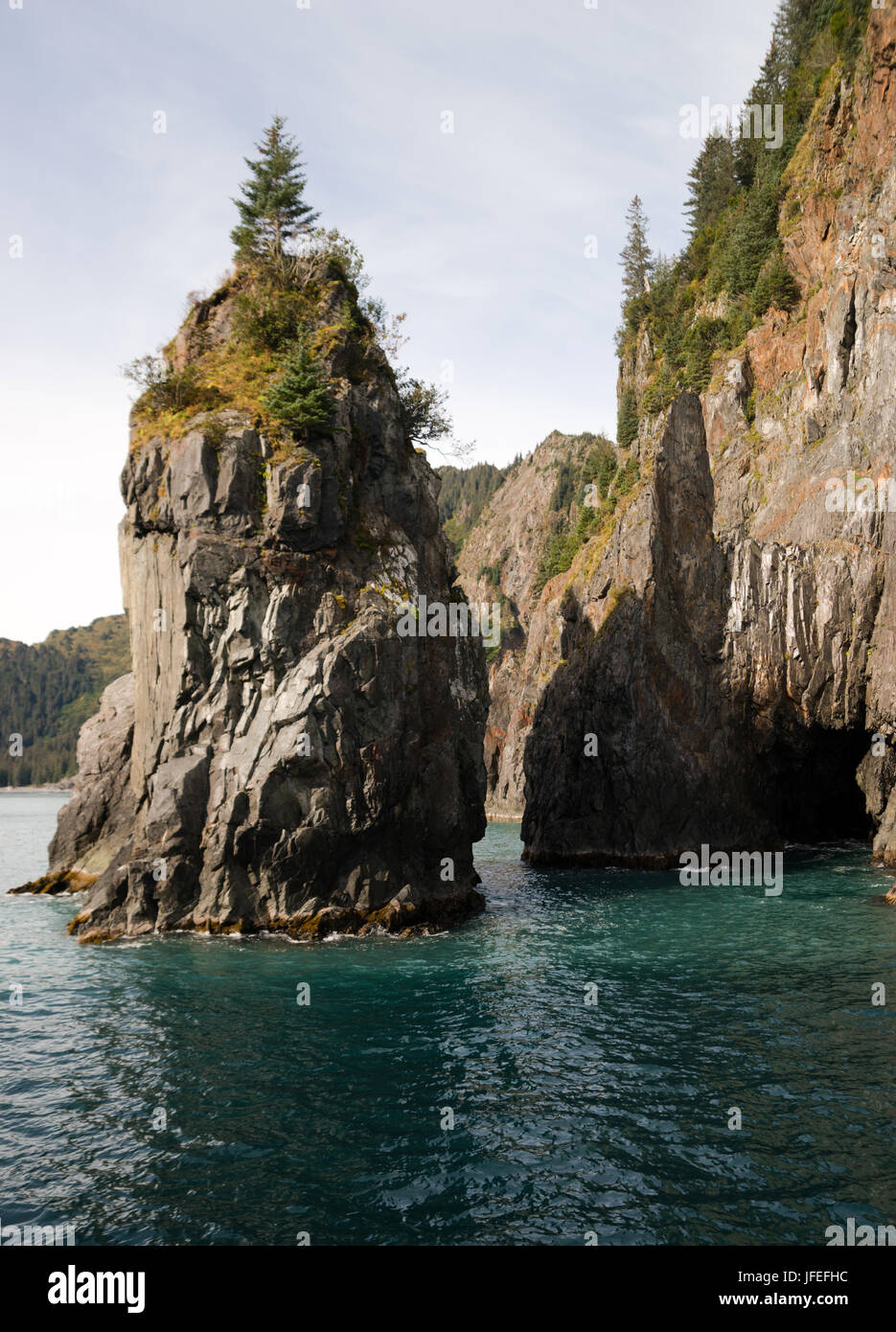 Beautiful rock buttes jut out of the ocean growing vegetation Stock Photo